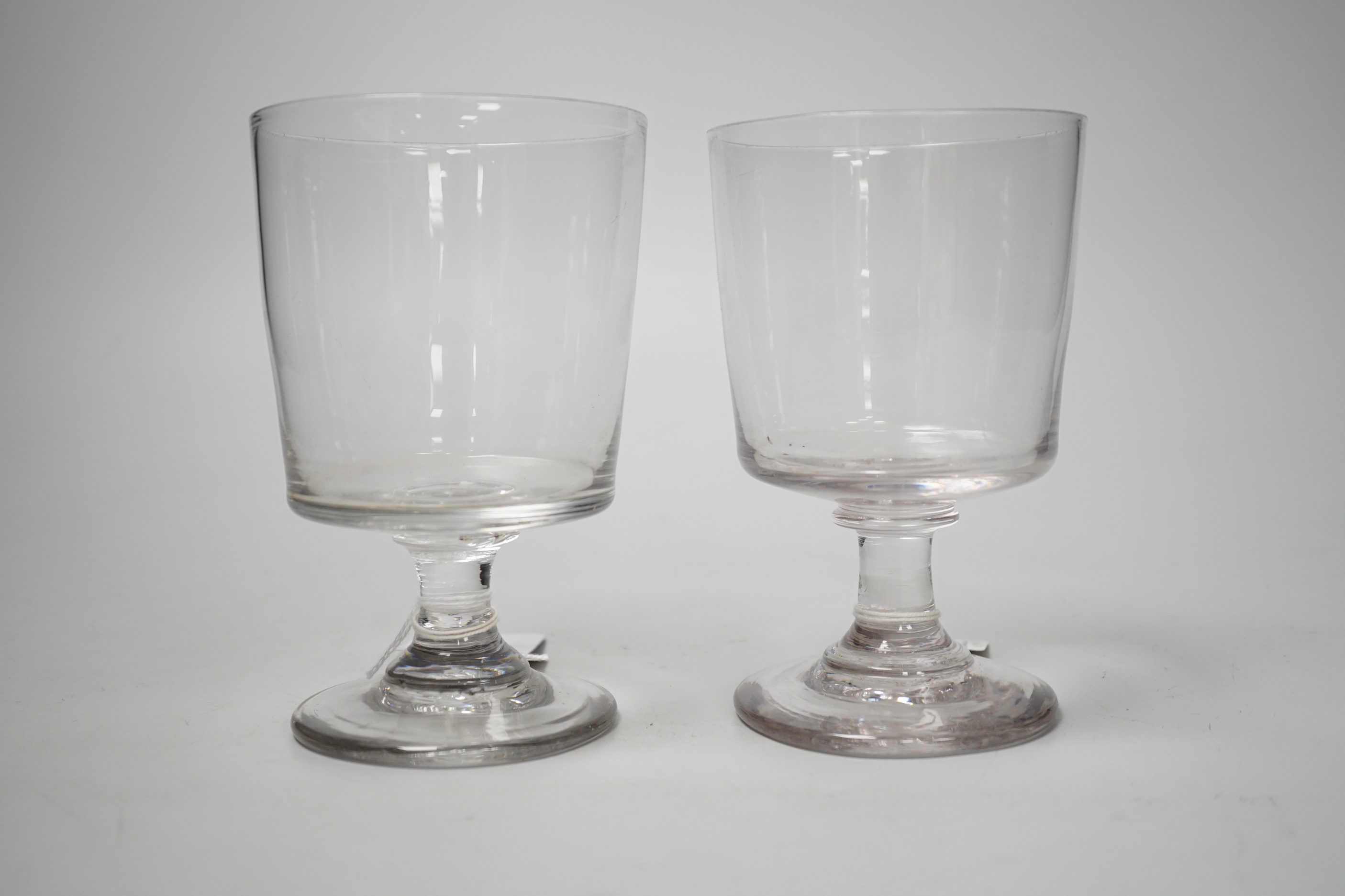 Two early 19th century English lead crystal rummers, in the form of square bucket shapes, with capstan stems and plain foot. 14.5cm highest